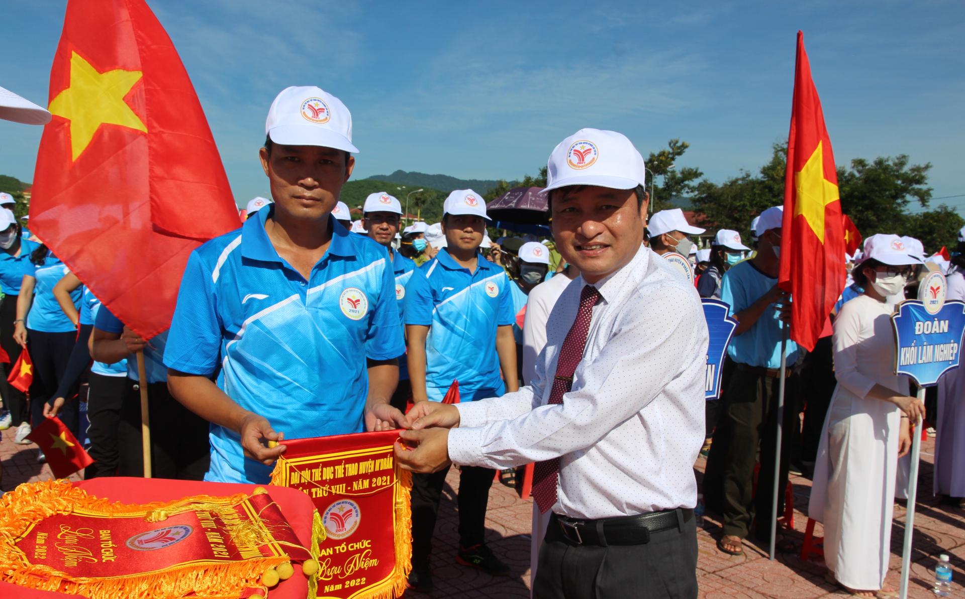 Tỉnh ủy viên, Bí thư Huyện ủy, Chủ tịch HĐND huyện M'Drắk Hồ Duy Thành trao Cờ lưu niệm tặng các đoàn dự đại hội.